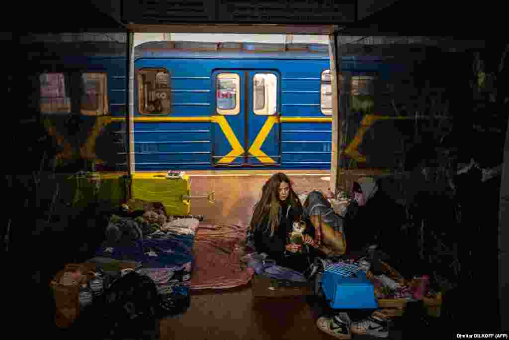 A woman hugs her cat in a subway station in Kyiv on March 8, 2022, where many people were forced to take shelter. Scenes reminiscent of World War II shocked the world in early March as Ukrainian civilians moved underground for safety while Russia launched missiles and rockets into several major cities.