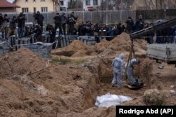 Corpurile persoanelor ucise și îngropate în gropi comune sunt dezgropate la Bucea, lângă Kiev. Imagine din 13 aprilie 2022. (AP Photo/Rodrigo Abd, File)