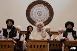 თალიბანის პრემიერ-მინისტრი მოჰამად ჰასან ახუნდი (შუაში) და ქველმოქმედების ხელშეწყობისა და პრევენციის მინისტრი შეიხ მოჰამად ხალიდი (მარცხნივ) შეკრებაზე ქაბულში ყოფილ საპრეზიდენტო სასახლეში. 2022 წელი