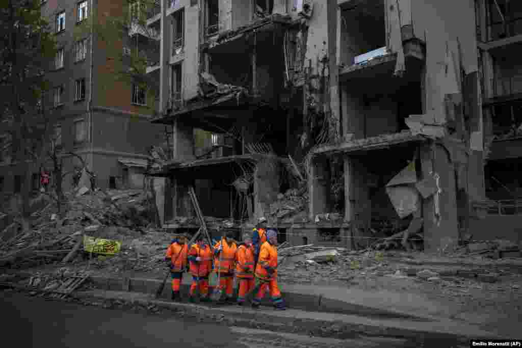 Cleanup crews prepare to work at the site of a Russian strike in Kyiv&nbsp;on April 28, 2022, that killed RFE/RL journalist Vira Hyrych, who had recently moved into the apartment building. At least 10 others were reportedly injured in the attack, which struck following a meeting between Ukrainian President Volodymyr Zelenskiy and UN Secretary-General Antonio Guterres.