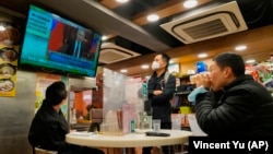 People in a Hong Kong restaurant watch a broadcast as Russian troops invade Ukraine on February 24, 2022.