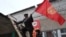 People fix national flags atop a local polling station in the Besh-Kungey village outside the Kyrgyz capital, Bishkek.