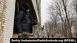 У розбитій школі: учень тримає залишки наочності у кабінеті біології