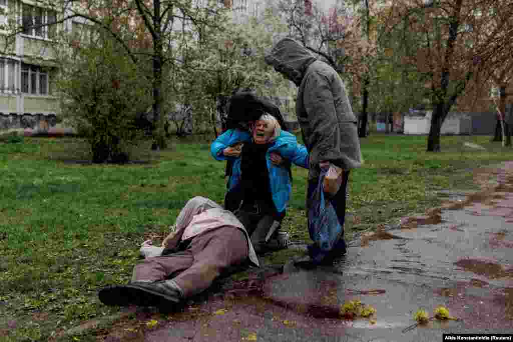 Yana Bachek is consoled by her partner, Yevhen Vlasenko, and her mother, Lyubov Hubareva, as she mourns over the body of her father, Viktor Hubarev, 79, who was killed by shelling in Kharkiv on April 18, 2022.