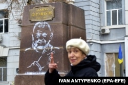 Місцева жителька Херсону проходить повз зображення головнокомандувача ЗСУ Валерія Залужного і напису «З нами Бог і отаман Залужний» на постаменті колишнього пам’ятника російському адміралу Ушакову. Херсон, 18 листопада. 2022 року