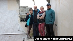 Maryna Snizhinska and her relatives stand in their destroyed house in the village of Dolyna, eastern Ukraine, on October 5.