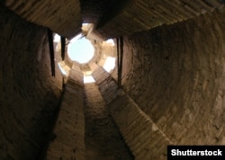 The interior of the minaret photographed from the top of a stairway that leads partway up the structure.