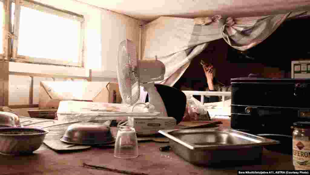 &quot;Nema provetrenosti prostorija, nema dovoljno prirodnog svetla, na podu je beton, okolo su goli zidovi. Struja je toliko slaba da mogu samo sijalice da upale i da pune telefone&quot;, rekao je za Radio Slobodna Evropa Danilo Ćurčić iz nevladine Inicijative A11 koji je 14. novembra posetio radnike. Na slici: Radnik u baraci u Zrenjaninu, 14. novembar 2021. &nbsp;