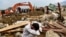 An Afghan villager reacts next to his destroyed house as rescuers search for survivors and bodies after a flash flood hit Parwan Province late last month. 