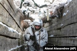 Український військовий йде по траншеї в Донецькій області на сході України, 27 січня 2022 року