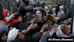 آرشیف - توزیع نان خشک رایگان به افراد نیازمند در کابل. 