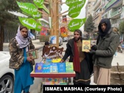 استاد مشعل در یک اعتراض مدنی و در مخالفت با سیاست های طالبان در برابر زنان و دختران برای مردم کتاب های رایگان توزیع می کرد