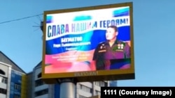 Украинадагы согушка тартылгандардын сүрөтү коюлган баннер. Москва. 2022-жыл. (Сүрөт "Азаттыкка" Вотсап аркылуу келди)