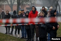 Locuitori din Brovarî privesc locul prăbușirii elicopterului în care e afla ministrul de Interne.