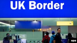 Un ofițer de poliție, aflat în patrulă la punctul de trecere al frontierei britanice de pe aeroportul Heathrow, 4 iunie 2014.