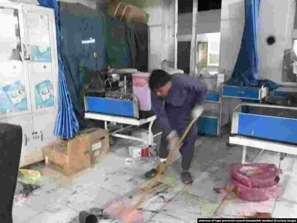 کارمند شفاخانه در حال پاک کاری توته های شیشه و غیره اشیا و وسایل که در اثر انفجار تخریب شده اند. &nbsp;