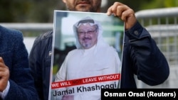 FILE: A demonstrator holds the picture of Saudi journalist Jamal Khashoggi during a protest in front of Saudi Arabia's consulate in Istanbul (October).