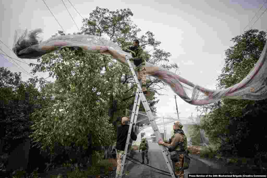 Українські бійці встановлюють антидронові сітки на дорозі поблизу Костянтинівки.«Костянтинівку постійно атакують дрони ворожих підрозділів «Рубікон» та «Судний день», сітки натягуються в умовах ударів FPV, авіації та артилерії», – повідомили у 24-й ОМБр імені Короля Данила.Фото пресслужби 24 ОМБр