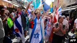 زائران مسیحی خارجی و دیگر حامیان توافق آتش‌بس در نوار غزه در بازار ماهانه یهودا در اورشلیم راهپیمایی می‌کنند