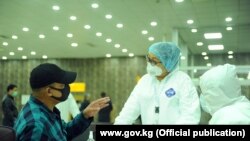 Gyrgyzystan. Manas aeroportunda COVID-19 barlagyndan geçýän ýolagçy. 18-nji mart, 2020