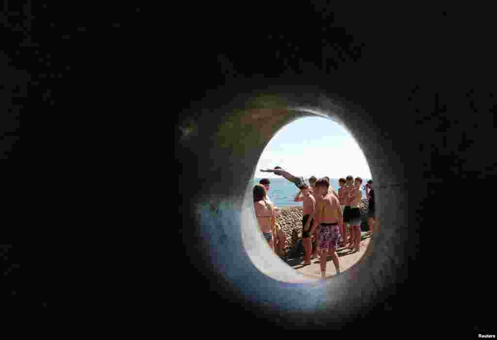 Человек прыгает с набережной в воду, во время жаркой погоды в летний день, Брайтон, Великобритания, 25 августа 2025 года. REUTERS/Toby Melville 