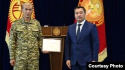 Тилек Жаныбай уулу получает награду от президента Садыра Жапарова.