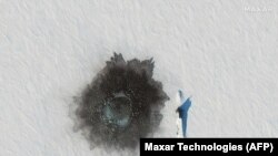 Un submarin văzute în mijlocul gheții în timpul exercițiului naval rus în Arctica, lângă insula Alexandra.