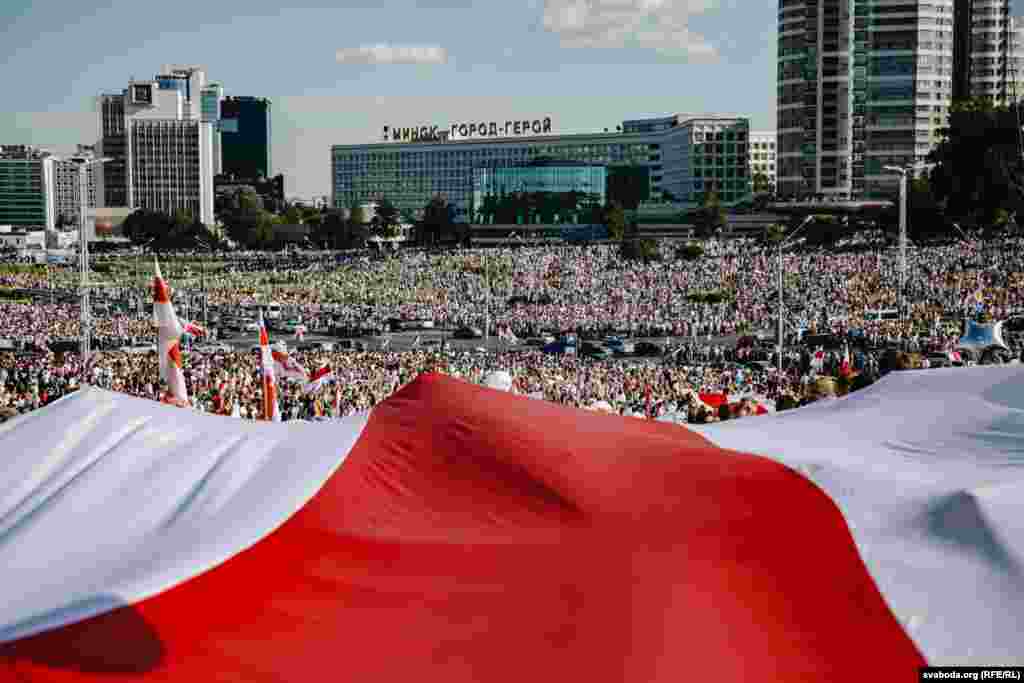 Тысячы людзей зь бел-чырвона-белымі сьцягамі прыйшлі да стэлы «Менск — горад-герой» падчас «Маршу свабоды» 16 жніўня 2020 году. Фота Радыё Свабода.