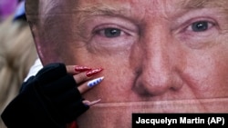  SUA - O femeie, cu un portret al președintelui Donald Trump miercuri, 6 ianuarie 2021, la Washington, la un miting în sprijinul său, cu câteva ore ca participanții la miting să ia cu asalt Capitoliul 