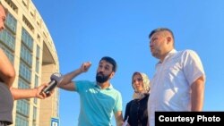 Alişer Sahatow (ortada) we beýleki türkmen aktiwistleri Türkmenistanyň Stambuldaky konsullygynyň işgärleri tarapyndan rehimsizlik bilen ýenjilenden soň türk žurnalistlerine interwýu berýär. Stambul, 2021.