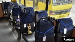 Jucării și etichete cu nume pe scaunele unui autobuz școlar la un eveniment simbolic de comemorare a celor 243 de copii uciși în războiul declanșat de Rusia în Ucraina, Lvov, 1 iunie 2022.