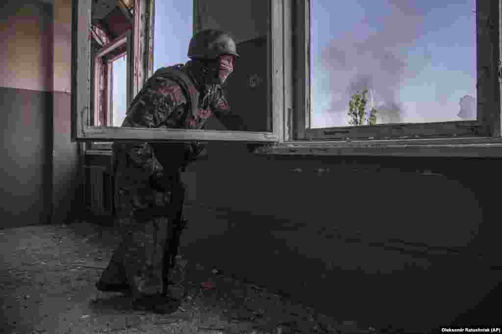 Un militar ucrainean privește bătălia care se desfășoară sub el în orașul Severodonețk.