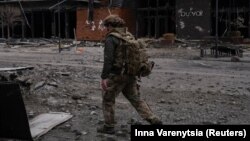 Український військовослужбовець проходить повз будівлю, пошкоджену російськими військовими ударами, в місті Покровськ Донецької області