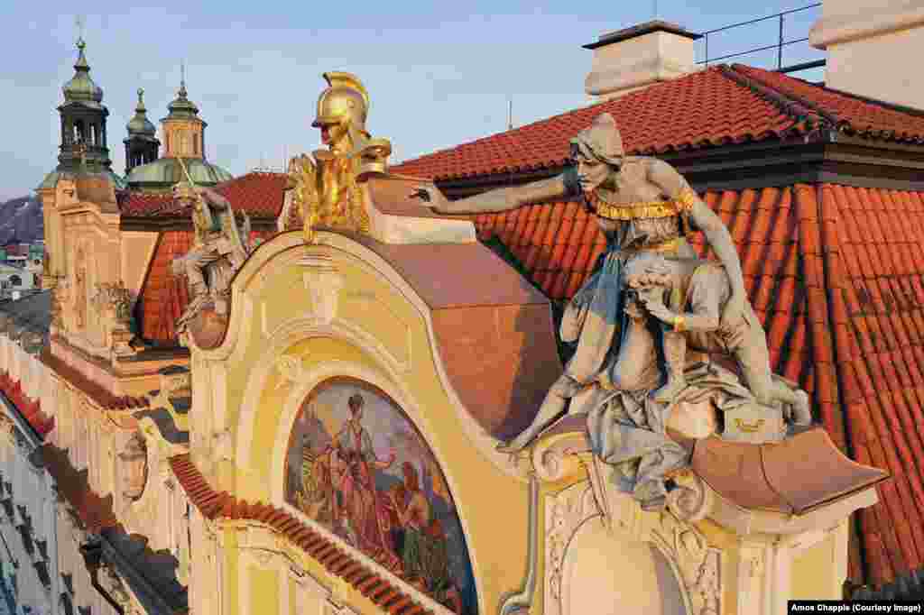 Друга фигура на покривот на стара прашка осигурителна компанија наречена &bdquo;повик за тревога&ldquo; покажува жена и дете што ги предупредува луѓето на пожар. Скулптурата била недовршена кога починал нејзиниот креатор Бохуслав Шнирх, а ја завршил неговиот практикант Ладислав Салун.