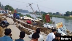 People gather near a damaged road after a 5.8 magnitude earthquake in Mirpur, Pakistan administered Kashmir on September 24.