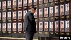 Ким Чен Ын стоит перед стелой с фотографиями военнослужащих Корейской народной армии (КНА), погибших на войне против Украины. Главный зал здания Центрального комитета Трудовой партии Кореи в Пхеньяне. 22 августа 2025 года