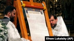 Священики ПЦУ представляють томос про автокефалію для Православної церкви України після Різдвяної Літургії в Софійському соборі в Києві, 7 січня 2019 року