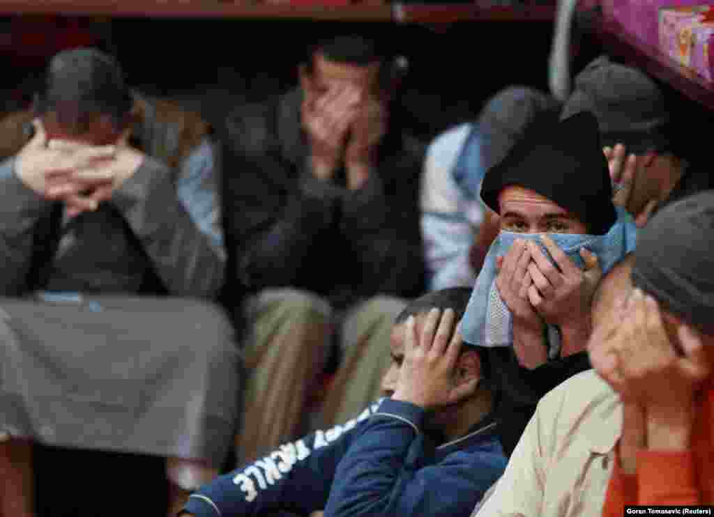 Prisoners from Iraq and Syria, suspected of being part of the Islamic State militant group, sit inside a prison cell in Hasaka, Syria.
