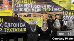 Protesters take part in a demonstration near the Uzbek Embassy in Berlin organized by Amnesty International against torture in Uzbek prisons in 2014.