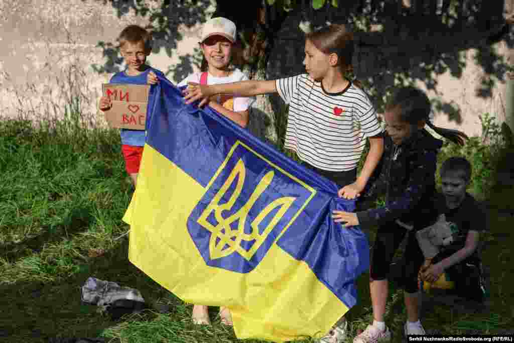 На цьому фото школярі місцевої школи, які приходять зустрічати українських захисників, які повертаються з російського полону, щоб підтримати їх