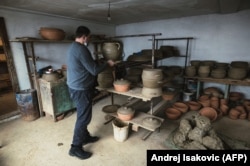Goran Savic places a pot to dry before it is baked.