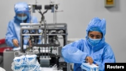 Шинжаңдагы беткап фабрикасында иштеген жумушчулар.  27-январь, 2020-жыл. Үрүмчү.