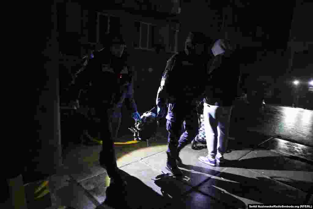 Співробітники поліції несуть предмет, схожий на двигун ударного БПЛА типу Shahed, якими Росія регулярно атакує Україну з повітря