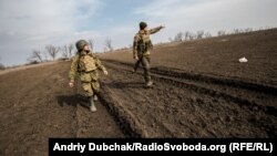 Матрос морської піхоти вказує капеланові Андрію на ворожі позиції та інструктує, що робити у випадку початку стрільби по нашій групі