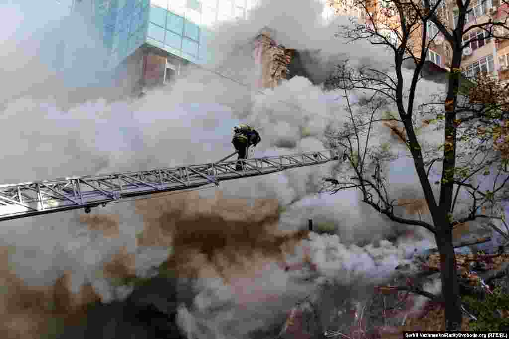 Пожежник піднімається по пожежній драбині для ліквідації наслідків влучання «Шахеда» у житловий будинок. Київ, 17 жовтня 2022 року