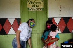 Түпкүлүктүү калктардын бири - мура элинин өкүлү болгон балалуу эне коронавируска каршы "Синовак" вакцинасы менен эмдеткени келди. Коррентеза кыштагы, Амазон аймагы, Бразилия. 2021-жылдын 13-февралы.