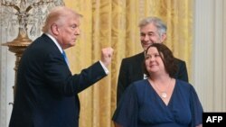 ټرمپ د جولای پر ۳۰مه په واشنګټن کې تر یوې غونډې وروسته له تالاره بهر روان دی.