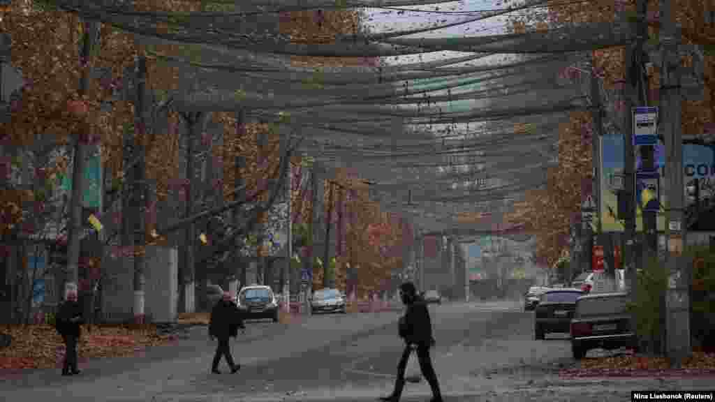 Nekoliko građana prolazi ulicom prekrivenom antidron mrežom u gradu Hersonu, 11. novembar 2025.