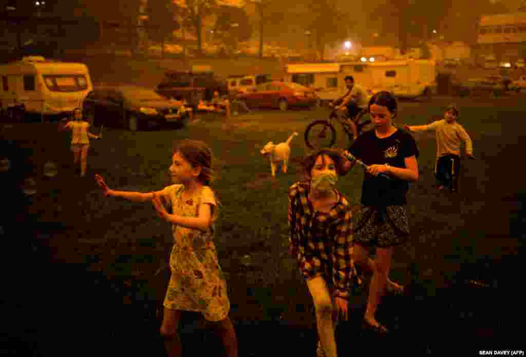 Дети играют на улице погруженного в дым городка в Новом Южном Уэльсе. Это один из наиболее пострадавших от пожаров штатов. В регионе сгорело около пяти миллионов гектаров леса и 1300 домов&nbsp;