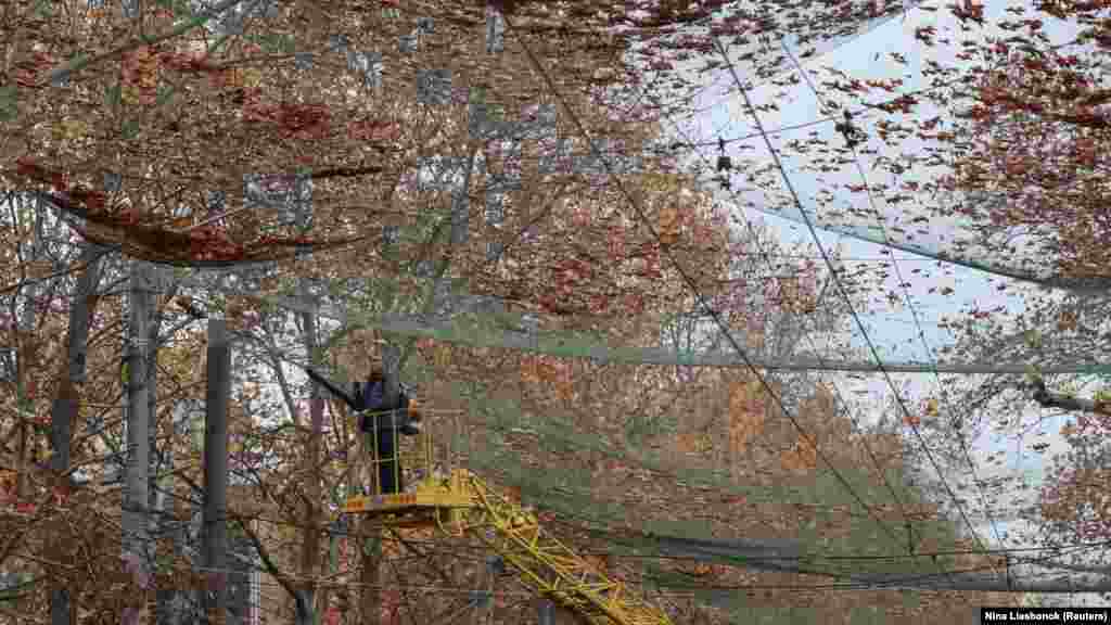 Komunalni radnik čisti antidron mrežu postavljenu u Hersonu, ukrajinskom gradu na liniji fronta. 11. novembar 2025.